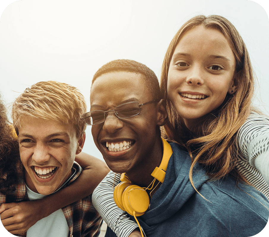 A group of young people posing together for a selfie and smiling.