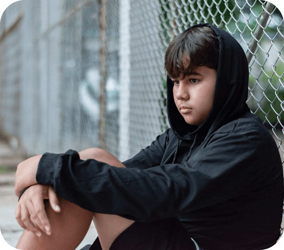 A young person sitting and looking thoughtful.